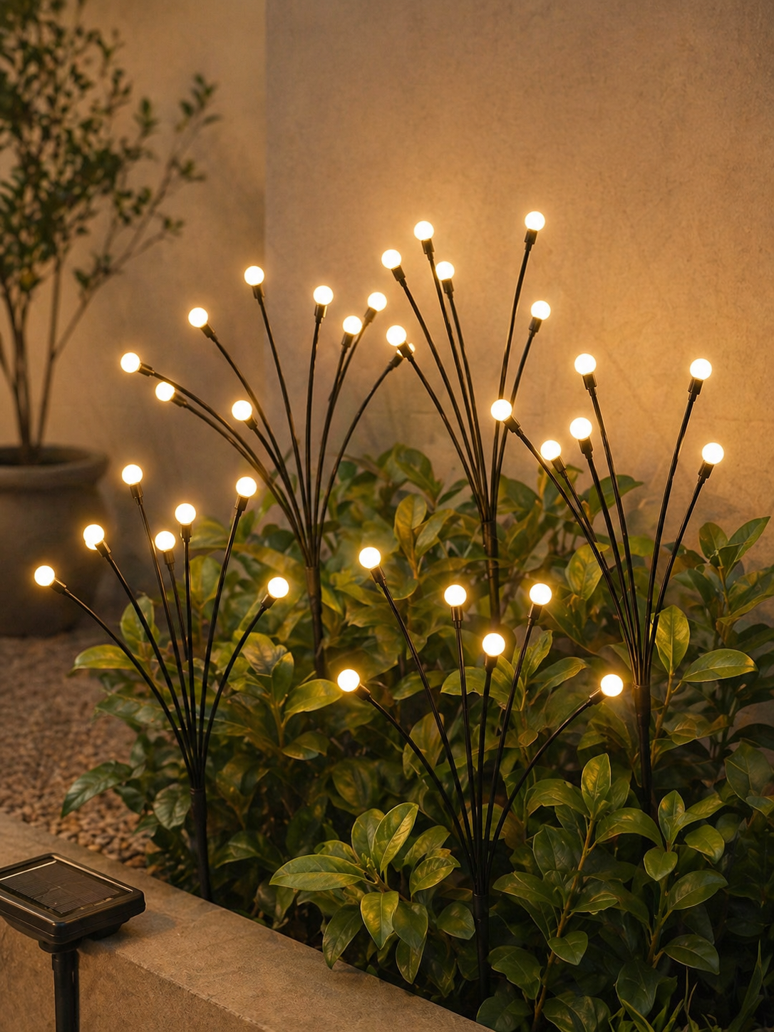 Warm solar garden lights glowing above leafy outdoor plants.